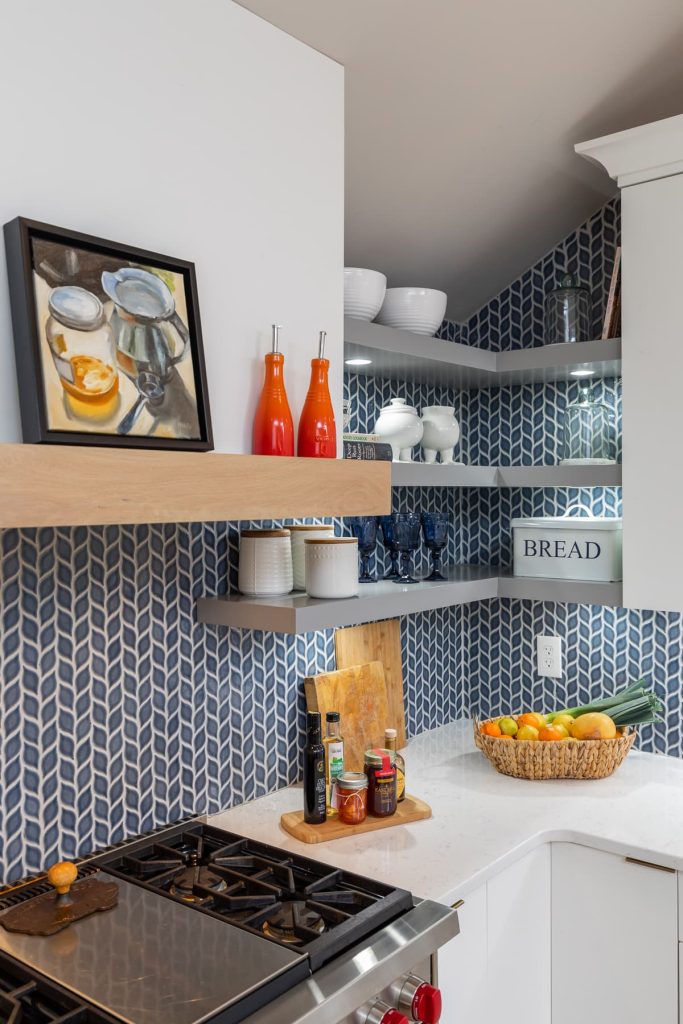 Blue Kitchen Back splash with grey floating shelves and white counter tops with white cabinets