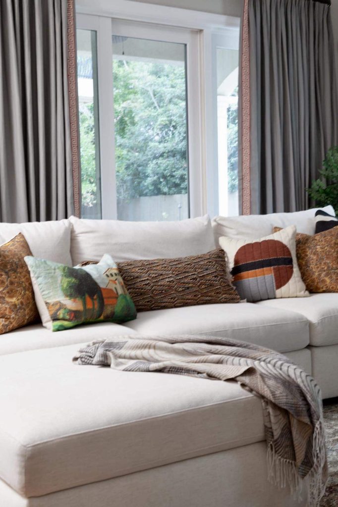 white upholstered sectional with throw pillows